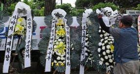 2일 서울 강동구 배재고등학교 앞에 한 관계자가 배재고등학교 야구부를 비판하는 근조화환을 놓고 있다./사진=뉴스