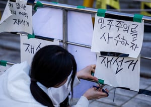지방선거 투표용지 부족 사태에 항의하며 개표소 시위를 이어가고 있는 시민들이 9일 재선거를 요구하는 문구를 붙이고 있다./사진=뉴시스