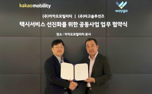 정주환 카카오모빌리티 대표(왼쪽)와 오광원 타고솔루션즈 대표가 업무협약식을 맺고 기념사진을 촬영하고 있다. /사진=카카오모빌리티