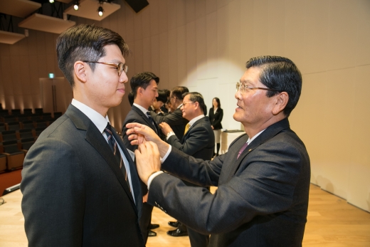 한화생명 차남규 부회장이 2019년 신입사원들에게 사령장 수여와 함께 회사 배지를 달아주고 있다. 한화생명은 용인 연수원에서 지난 7일부터 18일까지 8박 11일간 주52시간제 근무제와 디지털 세대 에 맞춘 새로운 신입사원 입문과정을 진행했다./사진=한화생명 제공