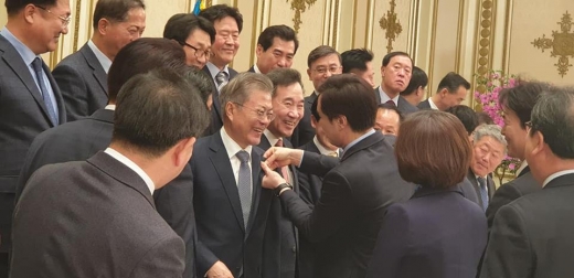▲ 서철모 화성시장이 지난 8일 문재인 대통령과 오찬 후 기념촬영에 앞서 화성시에서 제작한 3.1운동 100주년 기념 배지를 달아 주고  있다. / 사진=서철모 시장 페이스북 캡처.