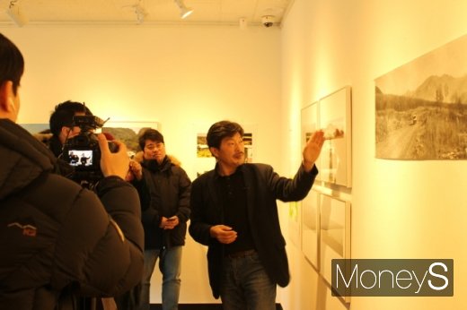 지난 9일 전시회를 개최한 신영담 작가가 관람객들에게 설명을 하고 있다. /사진=박정웅 기자