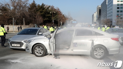 11일 오후 서울 여의도 국회 정문앞에서 한 택시기사가 분신을 시도해 경찰들이 화재진압을 하고 있다./사진=뉴스1 김명섭 기자