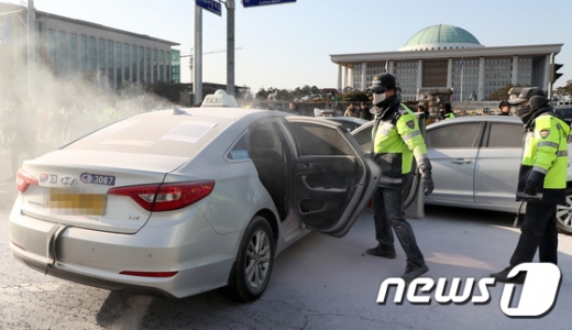 지난 11일 한 택시기사가 국회 앞에서 분신을 시도해 경찰들이 화재를 진압하고 있다. /사진=뉴스1