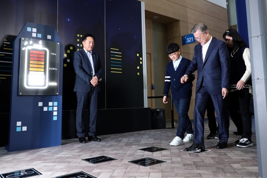 문재인 대통령이 13일 오전 부산 해운대구 벡스코에서 열린 스마트시티 전략발표회에서 발로 밟은 운동에너지를 전기로 만든 ‘압전에너지’ 기기를 개발한 에이치앤제이의 부스를 방문해 제품을 체험하는 모습. /사진=청와대