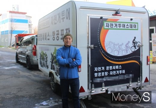 트레일러와 전용 승합차 앞에서 포즈를 취하는 최강 투어스테이 대표. /사진=박정웅 기자