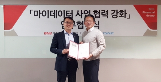 BNK부산은행은 지난 27일 개인금융 관리서비스 전문기업인 ㈜레이니스트와 ‘마이데이터 사업 협력 강화 업무협약’을 체결했다.( BNK부산은행 한정욱 디지털금융본부장(왼쪽) ㈜레이니스트 최재웅 본부장)/사진제공=부산은행