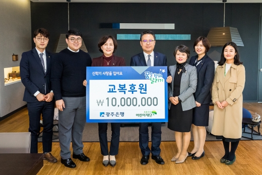 송종욱 광주은행장(왼쪽 4번째)이 김은형 초록우산어린이재단 본부장에게 교복 후원금 1000만원을 전달하고 있다.