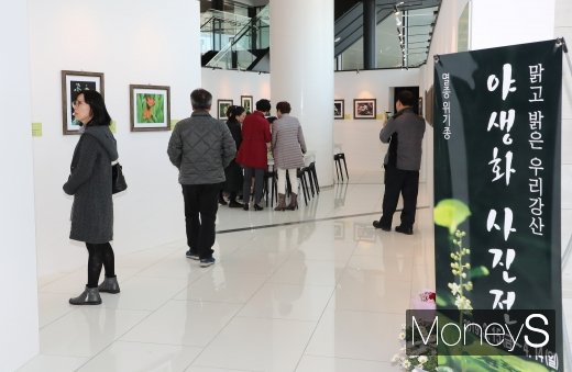 지난 15일 한수원 경주 본사에서 열리고 있는 ‘야생화 사진전’에서 관람객이 사진을 감상하고있다. /사진=한국수력원자력 제공.