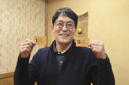 상익그룹산하 안상경 소장이 안청락 회장과 본인의 카드를 들고 웃고 있는 모습./사진제공=주식회사 아라사