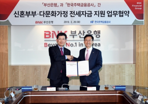 BNK부산은행(은행장 빈대빈, 왼쪽)은 지난 26일 본점에서 서민 주택금융 지원을 위해 한국주택금융공사(사장 이정환, 오른쪽)와 ‘신혼부부·다문화가정 전세자금 지원 업무협약’을 체결했다./사진제공=부산은행
