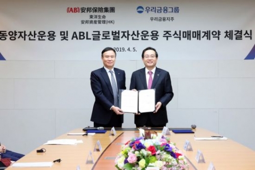 지난 5일 서울 소공동 한진빌딩 본관에서 손태승 우리금융그룹 회장(오른쪽)과 뤄젠룽 동양생명 사장이 SPA(주식매매계약) 체결 기념사진을 촬영하고 있다./사진=우리금융