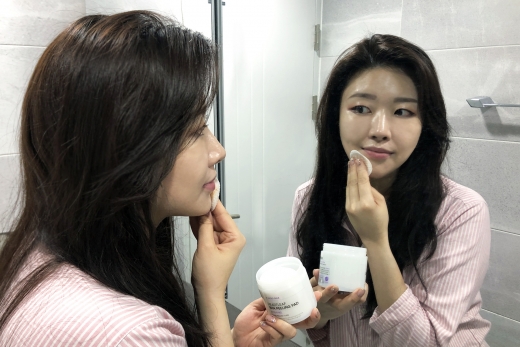 한 여성이 랄라블라에서 판매하는 셀리맥스의 '지우개패드' 제품을 이용해 피부결을 정리하고 있다/사진=GS리테일