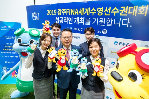 송종욱 광주은행장(가운데)이 본점 1층 로비에서 2019 광주세계수영선수권대회 마스코트 수리&달이를 들고 직원들과 기념촬영을 하고 있다./사진=광주은행 제공.