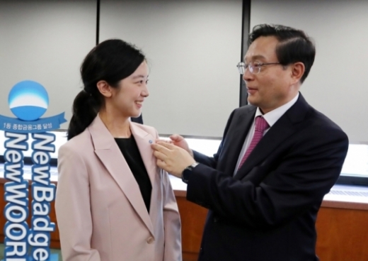 지난 12일 손태승 우리금융 회장이 직원에게 새로운 배지를 달아주고 있다./사진=우리금융