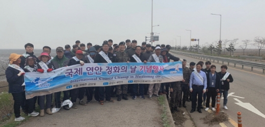 ▲ 지난 19일 화성방조제에서 민·군·관 합동으로 해양환경정화행사가 펼쳐진 가운데, 참석자들이 파이팅을 외치고 있다. / 사진제공=화성시 