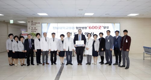지난 18일 전남대병원 1동 로비에서 열린 협력병원 600곳 달성 기념식에서 이삼용 전남대병원장이 여수예울병원 문종호 원장에 협력병원 명패와 협약증서를 전달하고 기념촬영을 하고 있다./사진제공=전남대병원