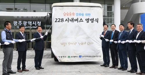 이용섭 광주광역시장이 26일 오전 시청 행정동 앞 광장에서 광주·대구 달빛동맹 강화를 위한 '228버스 명명식'에 참석해 권영진 대구광역시장과 함께 버스 가림막 제거 세리모니를 하고 있다./사진제공=광주광역시