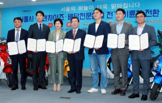 24일 오전 서울시청에서 열린 서울시ㆍ프랜차이즈ㆍ배달전문업체 전기 이륜차 전환 상생협약식'에서 박원순 서울시장을 비롯한 참석자들이 협약서에 서명한 뒤 기념촬영을 하고 있다. 왼쪽부터 황학수 교촌에프앤비 총괄사장, 유지영 한국피자헛 이사, 조주연 한국맥도날드 대표, 박원순 서울시장, 윤현준 우아한청년들 대표, 유정범 메쉬코리아 대표, 이태권 바로고 대표 