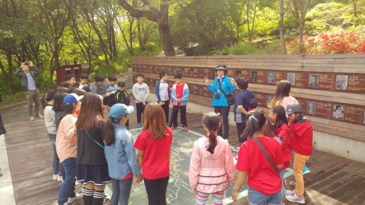 ▲ 망우리공원에서 문화관광해설사가가 근.현대사 인물들에 대해 해설하고 있다. / 사진제공=구리시
