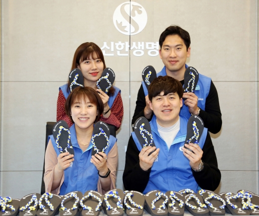 신한생명은 지난달 ‘폴짝 신발 만들기’ 캠페인을 진행하여 직원 봉사자들이 만든 800개의 폴짝 신발을 보건 위생키트와 함께 아프리카 탄자니아 어린이들에게 전했다. 직원 봉사자들이 폴짝 신발을 들고 기념촬영을 하고 있다./사진=신한생명