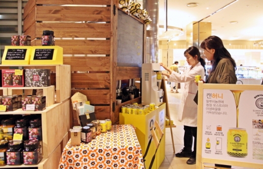 허니앤코 마누카꿀을 캔에 놓는 장면./사진제공=신세계센텀시티