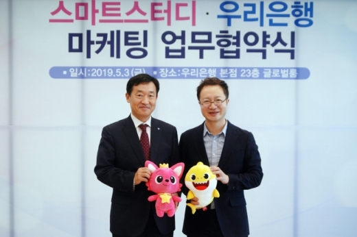 우리은행은 지난 3일 스마트스터디와 영유아 마케팅 강화를 위한 업무 협약을 체결했다. 정채봉 우리은행 영업부문장과 이승규 스마트스터디 CFO 가 핑크퐁과 아기상어 인형을 들고 기념사진 촬영을 하고 있다./사진=우리은행