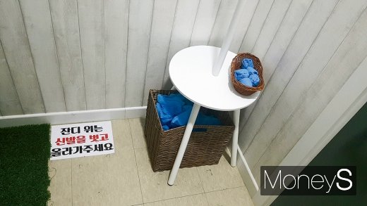 안마카페 내 양말이 놓인 탁자와 바닥에 깔린 잔디. /사진=김정훈 기자