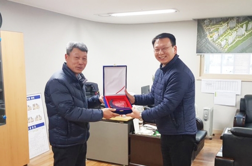 화성 동탄 68블록 입주자 모임 대표가 민병춘 현장 소장(오른쪽)에게 감사패를 전달하고 있다./사진=중흥건설 제공