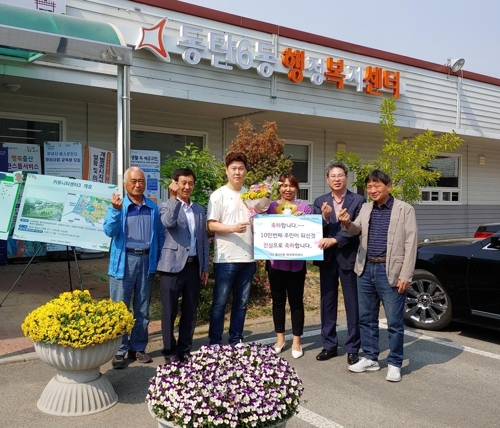 동탄6동 10만 번째 전입자 최형욱씨(왼쪽에서 세 번째)를 환영하고 있는 모습. / 사진제공=화성시