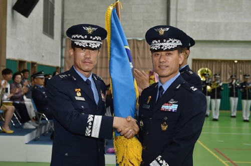 17일 오전 광주 광산구 공군 제1전투비행단 선봉스포렉스에서 열린 '제49·50대 단장 이·취임식'에서 신임 단장 권오석 준장(오른쪽)이 공중전투사령관 최성천 소장으로부터 부대기를 인수받으며 기념사진을 촬영하고 있다./사진제공 = 공군 제1전투비행단 