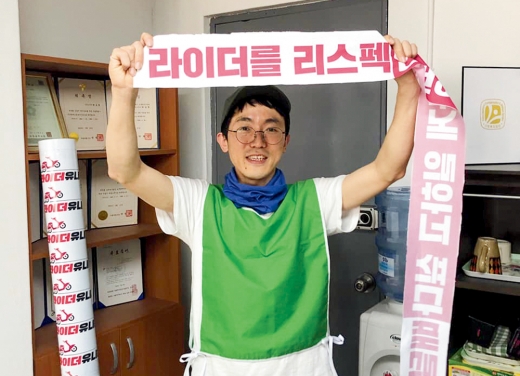 박정훈 라이더유이온 위원장이 ‘라이더를 리스펙’이라는 문구가 담긴 머플러를 들고 있다. /사진=라이더유니온 공식페이스북 캡처