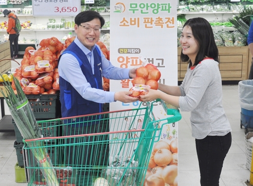 노명하 농협광주농산물종합유통센터 사장(왼쪽)은 30일 유통센터 내 하나로마트에서 무안 황토랑 양파 소비 판촉활동을 벌이고 있다./사진=농협전남지역본부 제공.