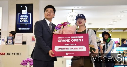 [머니S포토] 인천공항 입국장 SM면세점 1호 고객에 선불카드 증정