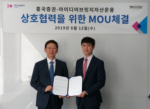 (왼쪽부터) 주원 흥국증권 대표이사와 김문수 아이디어브릿지자산운용 대표이사가 12일 광화문 흥국증권 본사에서 협약을 체결하고 양해각서를 들어보이고 있다. /사진=흥국증권