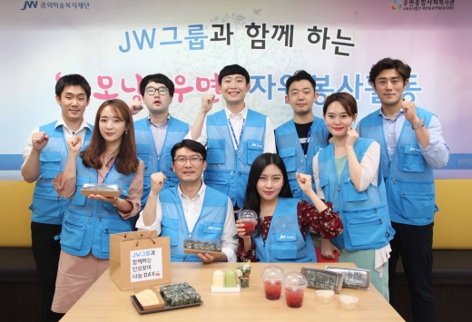 JW한마음봉사단원들이 단오 전통 음식을 만들고 기념촬영을 하고 있다. /사진=JW그룹