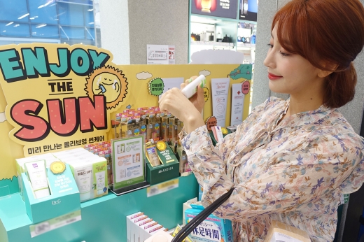 올리브영 명동본점을 방문한 고객이 선케어 제품을 살펴보고 있다.