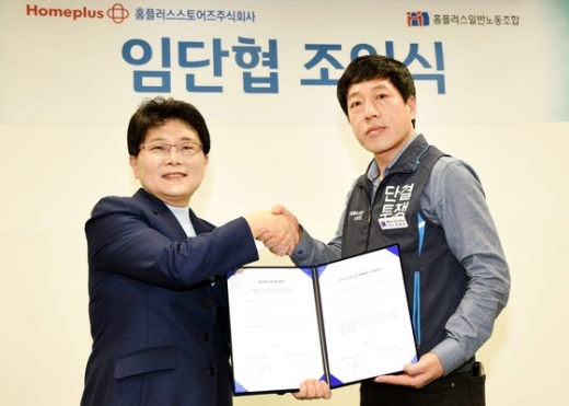 임일순 홈플러스 사장(왼쪽)과 이종성 홈플러스일반노동조합 위원장(오른쪽)이 지난 3월 2019년 임금ㆍ단체협약 조인식을 마친 후 협약서를 함께 들어 보이며 악수를 나누고 있다. 홈플러스 노사는 당시 무기계약직 연내 정규직 전환 등에 합의했다.
