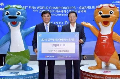 이용섭 광주광역시장이 3일 오전 서울 용산역 대합실에서 구본환 인천국제공항공사 사장으로부터 수영대회 기부금 증서를 전달 받고 있다./사진제공=광주광역시