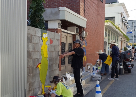 영산대학교 시각디자인학부 학생들이 해리단길 에 벽화를 그리고 있다./사진제공=해운대구 