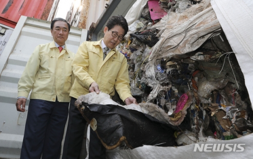 조명래 환경부 장관(오른쪽)과 정장선 평택시장이 지난 4월 경기 평택항 동부두 컨테이너터미널에서 국내로 반입된 필리핀 불법수출 폐기물 행정대집행에 앞서 컨테이너 속 폐기물을 살펴보고 있다. / 사진=뉴시스