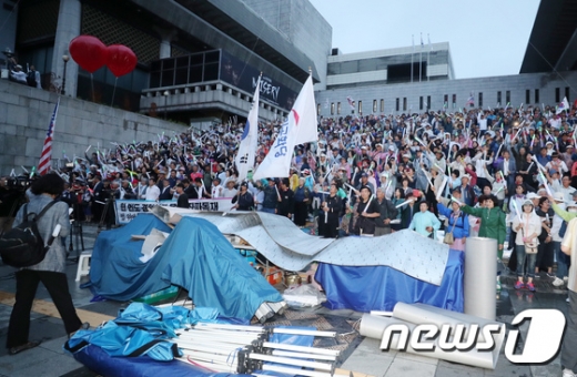 우리공화당 당원과 지지자들이 16일 오전 서울 세종문화회관 앞 계단에서 광화문광장에 설치됐던 천막을 자진 철거 후 구호를 외치고 있다. /사진=뉴스1