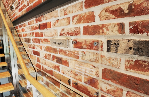 신흥3 재개발구역 내 담장에 사용됐던 벽돌로 꾸민 신흥 SK뷰 견본주택 내부계단 측벽. /사진=SK건설