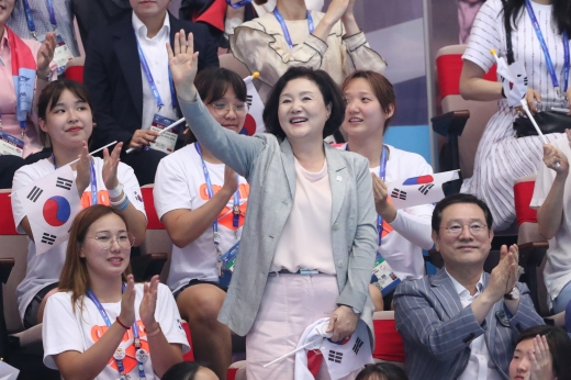 김정숙 여사가 지난 22일 오후 광주 광산구 남부대 시립국제수영장에서 열린 2019 광주세계수영선수권대회에서 이용섭 조직위원장과 김서영의 경기를 관람하기에 앞서 관중을 향해 손을 흔들고 있다./사진제공=광주세계수영선수권대회 조직위