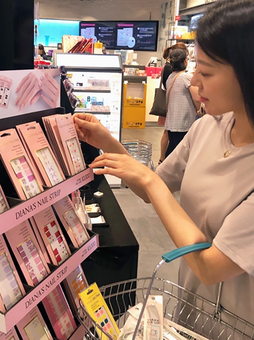 고객이 랄라블라 매장에서 셀프 네일 및 패디제품을 살펴보고 있다