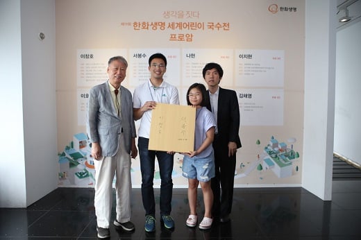 23일 여의도 63빌딩에서 열린 한화생명 세계어린이 국수전 프로암 이벤트 대회 후  친필 사인이 담긴 바둑판을 증정받은 아마추어 기사들이 서봉수 9단(왼쪽 첫번째)과 이창호 9단(오른쪽 첫번째)과 함께 기념촬영을 하고 있다. / 사진=한화생명