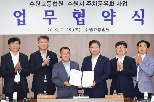염태영 수원시장(왼쪽에서 4번째)과 김주현 수원고등법원장이 25일 법원 소회의실에서 '주차 공유 협약'을 체결 후 악수하고 있다. / 사진제공=수원시