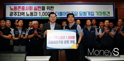 ▲29일 윤종해 한국노총 광주본부의장이 광주광역시의회 브리핑룸에서 송갑석 더불어민주당 광주시당위원장에게 당원 가입패를 전달하고 있다.