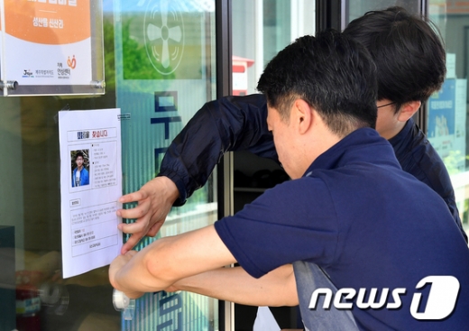 1일 제주 서귀포시 표선면 인근 마을의 무더위 쉼터에 제주도교육청 관계자들이 유동현군(18)의 전단지를 붙이고 있다. /사진=뉴스1