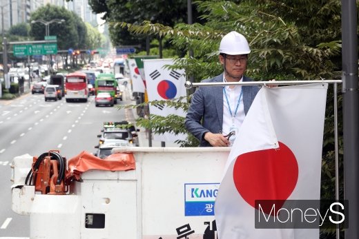 2일 오후 서울 강남구 테헤란로에서 구청 관계자가 일본정부의 ‘화이트리스트’ 한국 제외 조치에 대한 항의 표시로 거리에 게양된 일장기를 철거하고 있다.  /사진=장동규 기자